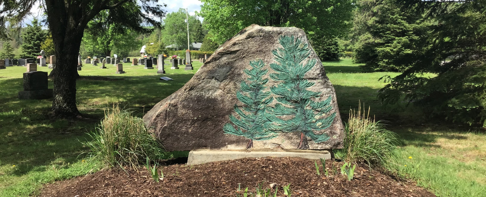 rock with trees decorated on it located in the Evergreen Cemetery